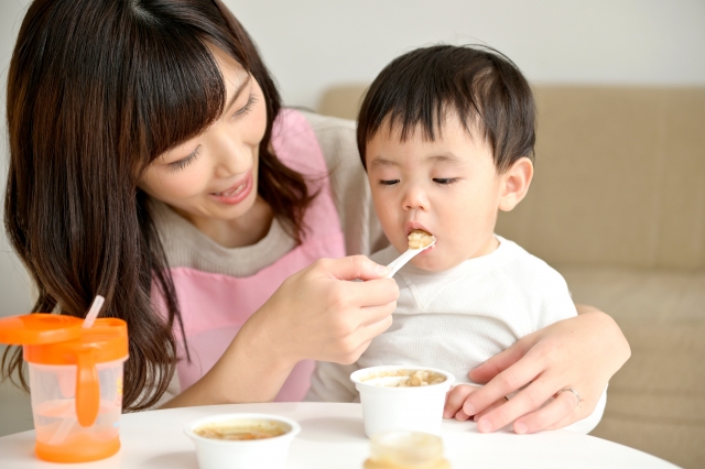 スプーンで離乳食をあげている